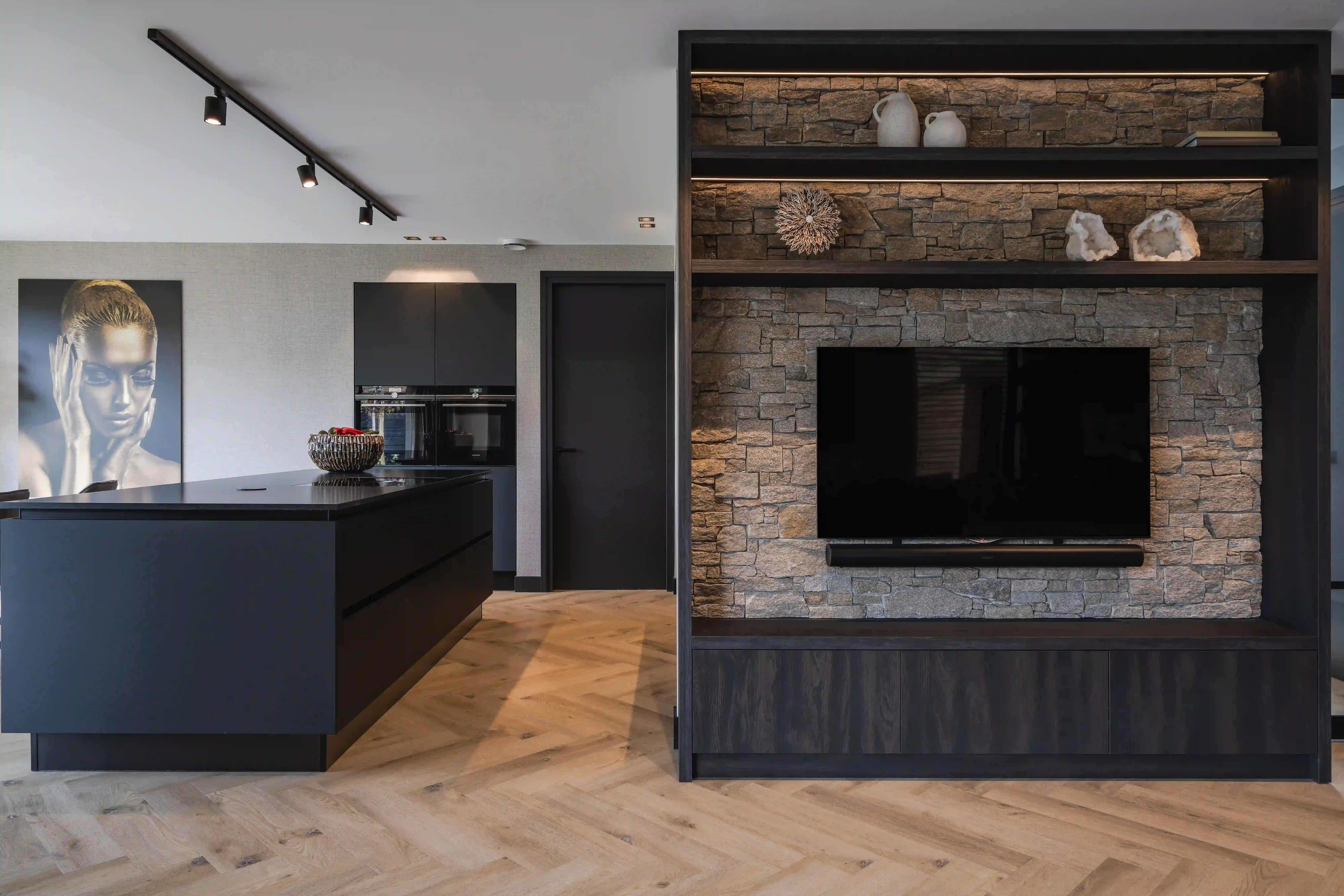 Villa Rotterdam - Keuken met stenen TV-wand en zilveren portret kunstwerk