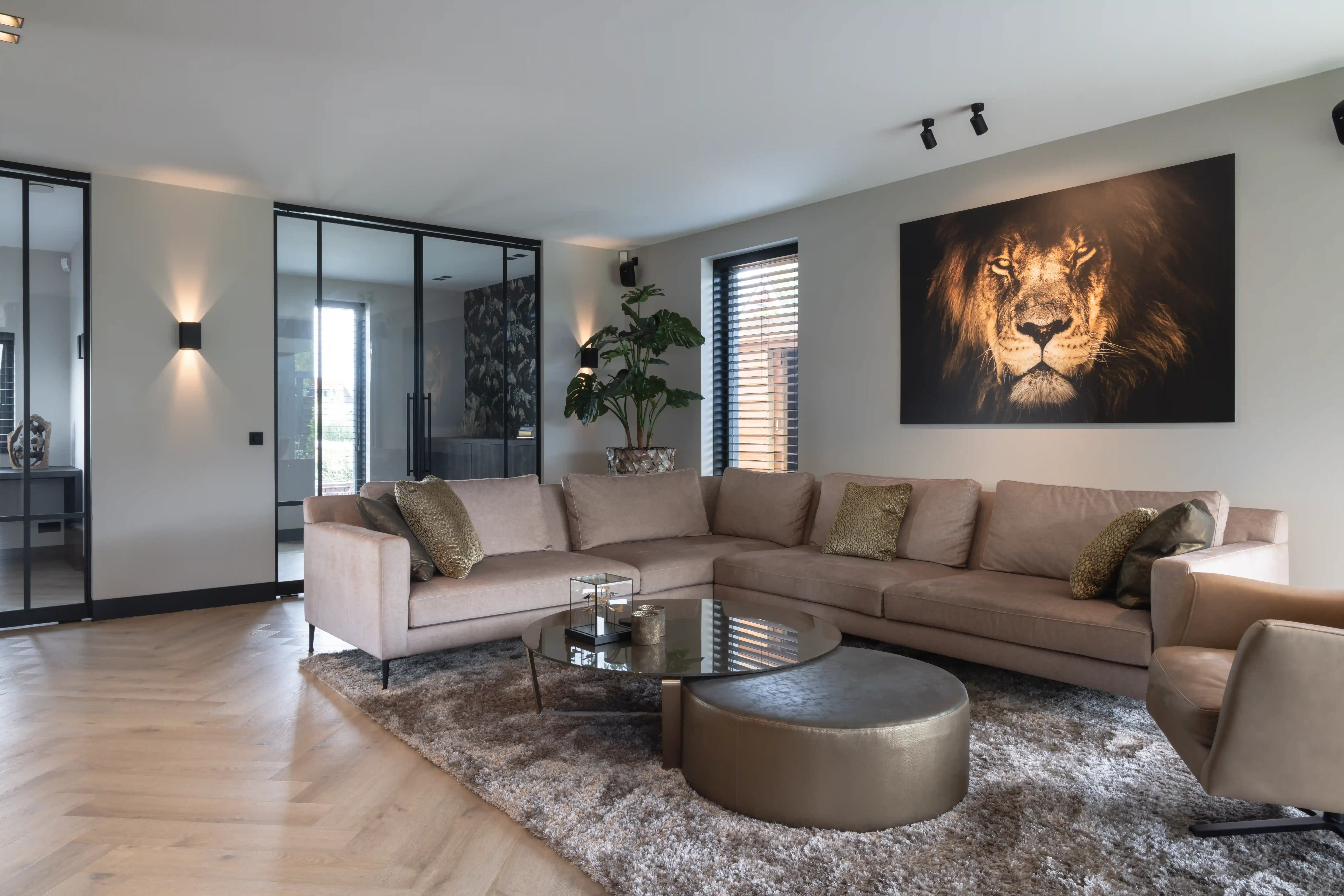 Villa Rotterdam - Woonkamer met beige hoekbank en leeuw kunstwerk