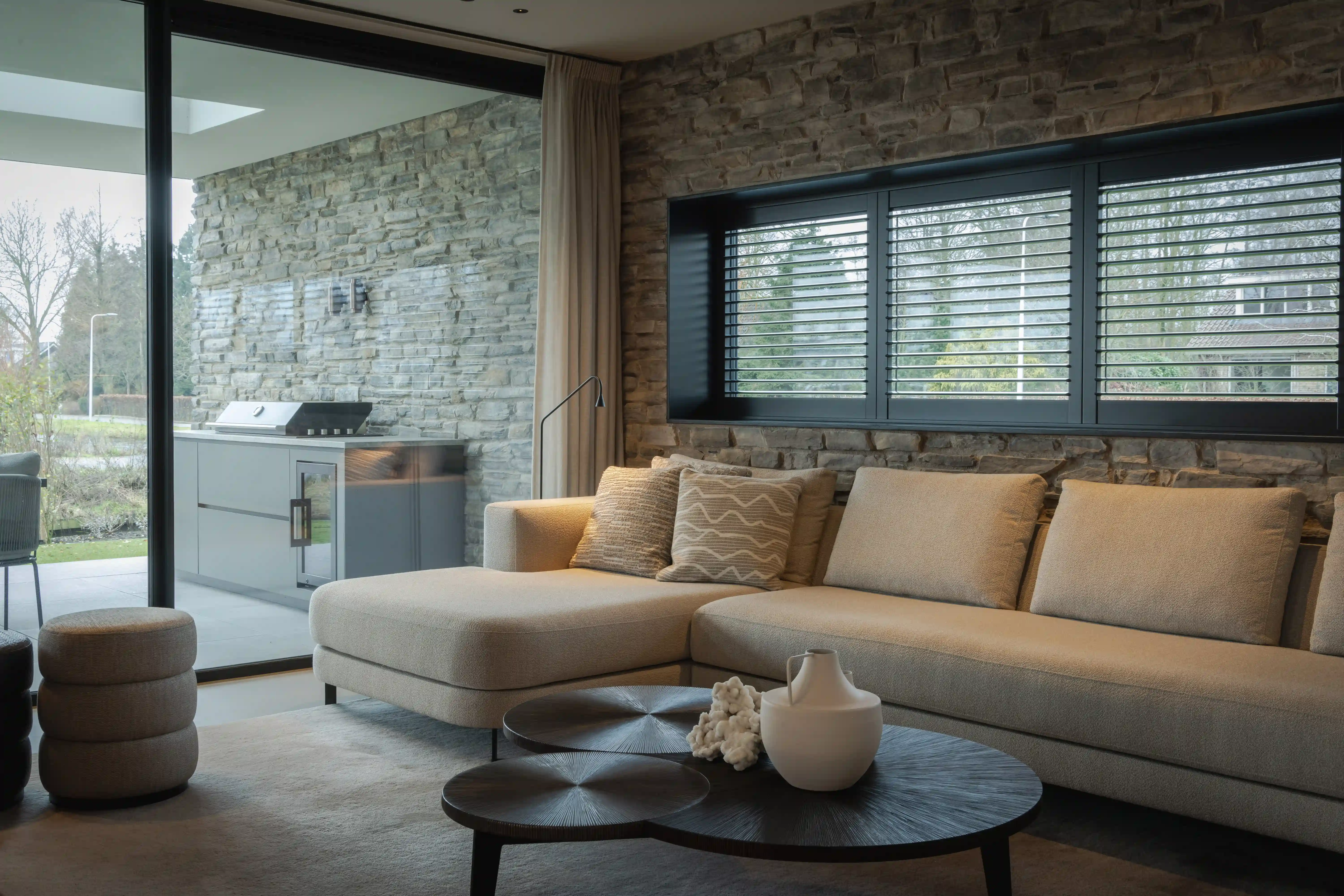 Villa aan het Water - Woonkamer met stenen muur en buitenkeuken