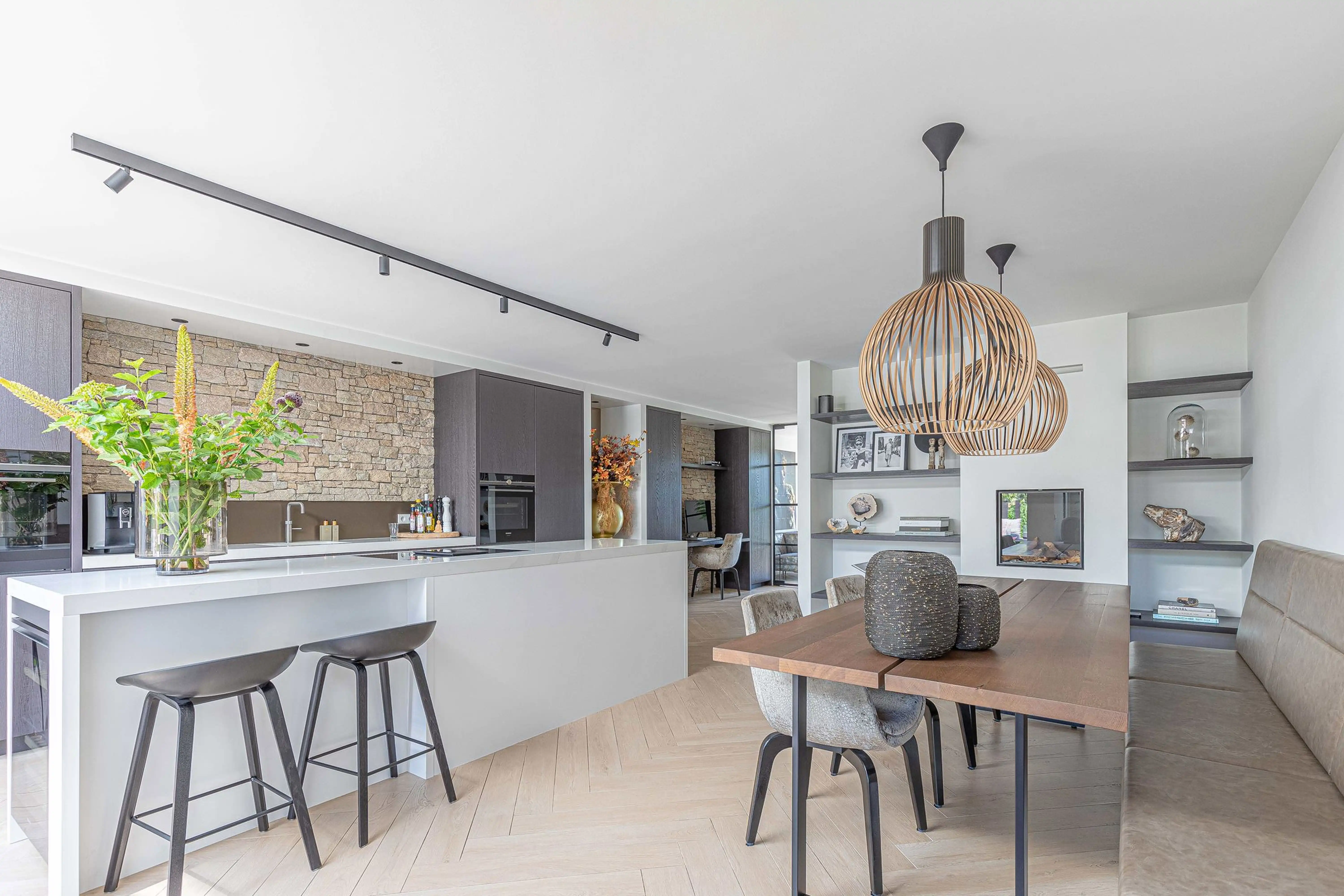 Wonen aan het water Reeuwijk 2 - Kitchen with bar stools and stone accent wall